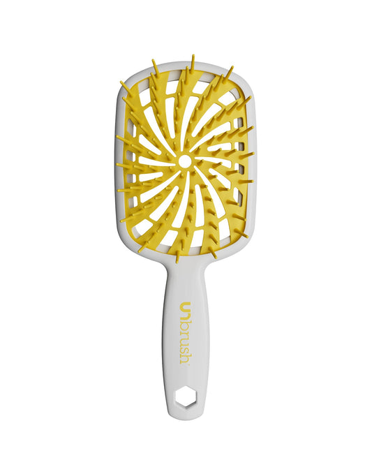 White Unbrush Plus detangling brush with yellow spiral bristle pattern, designed for gentle use on wet or dry hair.