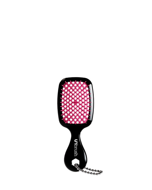 A black UNbrush keychain with pink bristles, featuring a handle and chain
