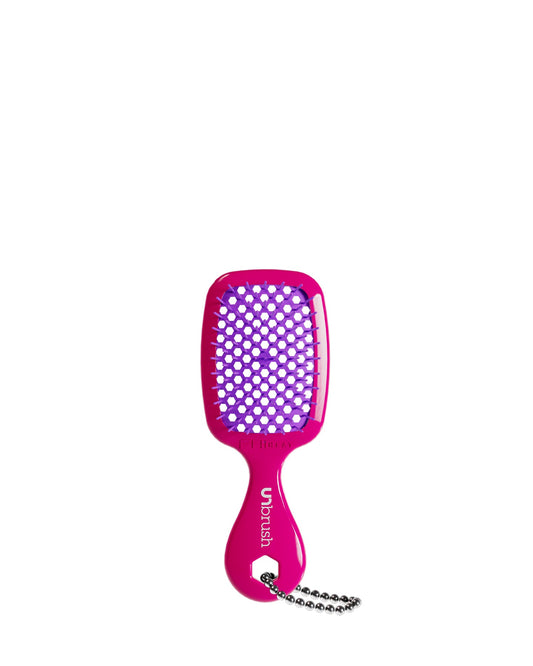 A hot pink UNbrush keychain with purple bristles, featuring a handle and chain